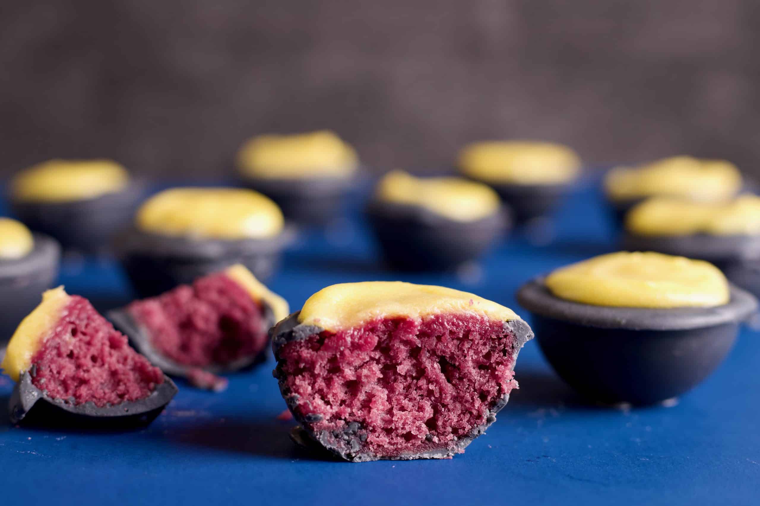 grey coated mini cakes, filled with blackberry cake and topped with lemon curd